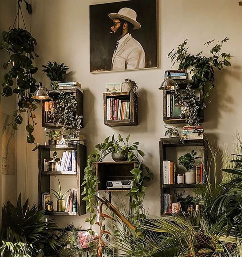 artwork books and decor on wall with greenery