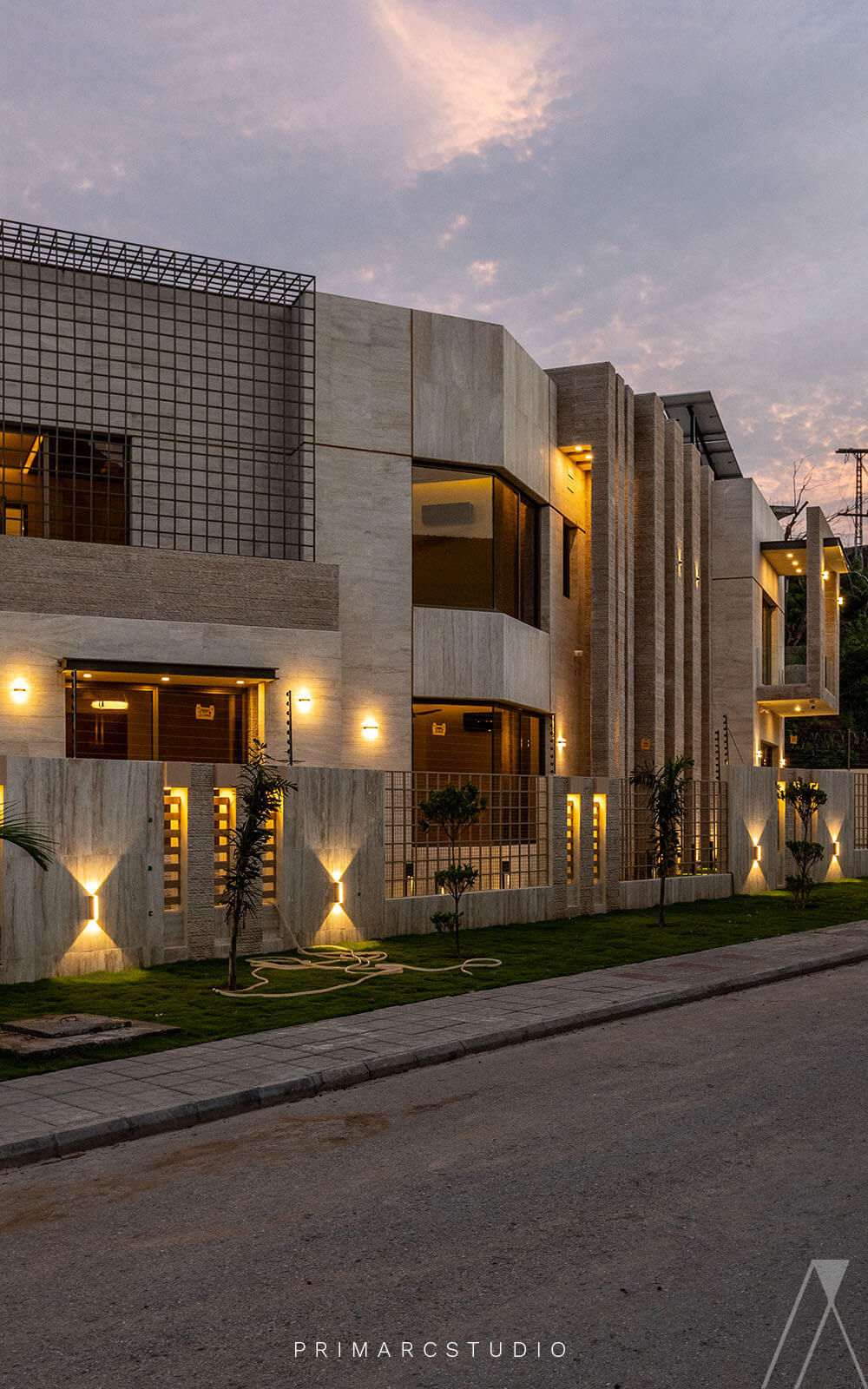 Evening view of boundary wall with exterior design of house