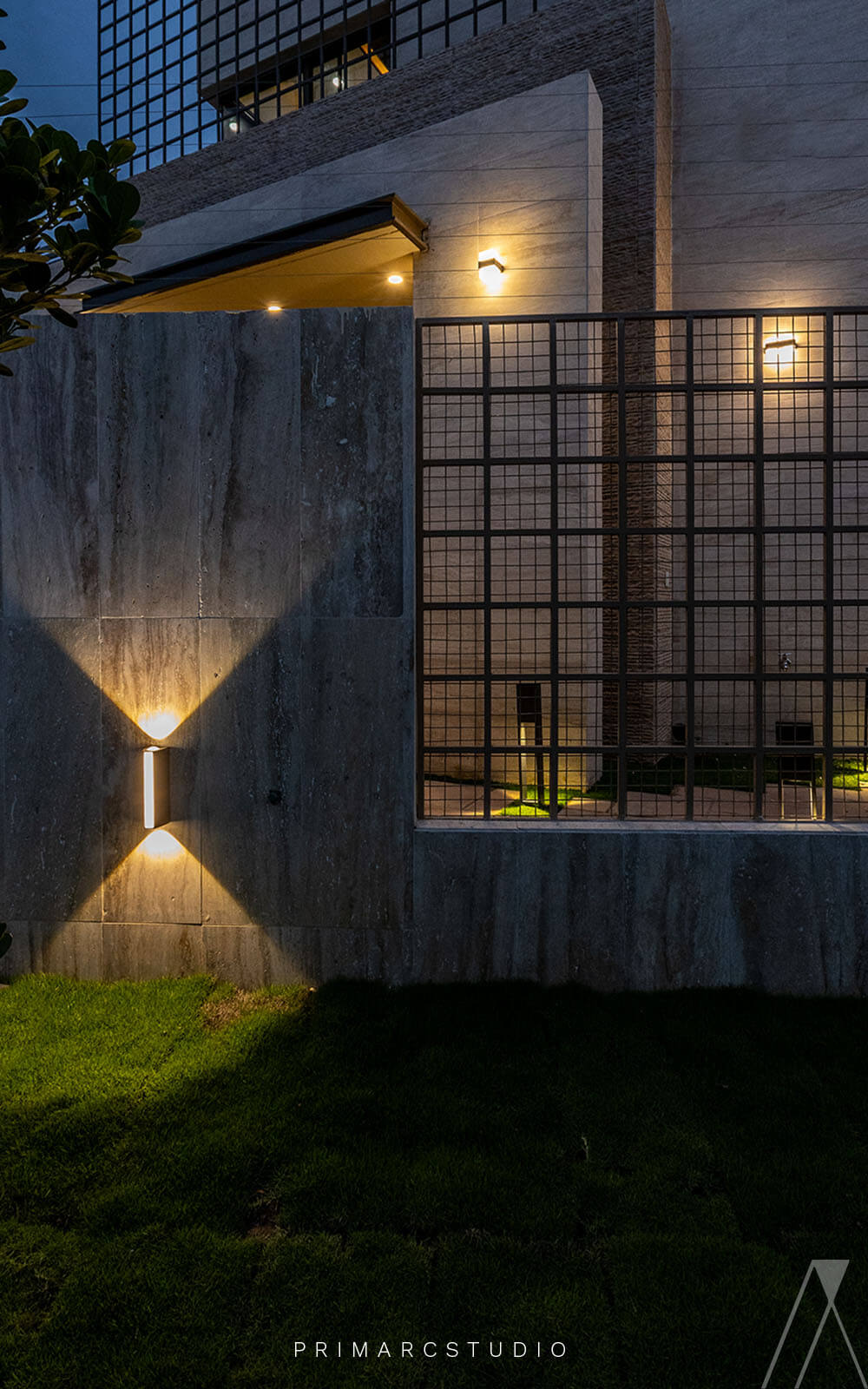 Boundary wall design with exterior lighting on house.