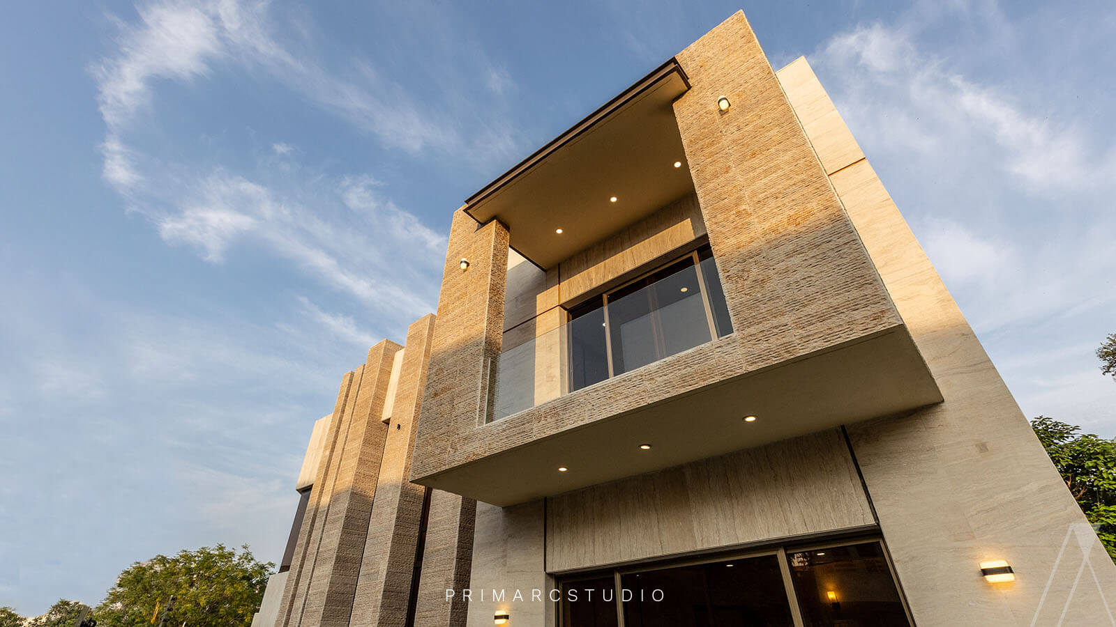 View of modern house with balcony and travertine on exterior