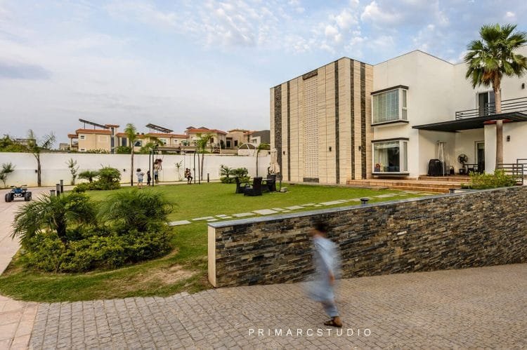 Modern farm house design with child running infront of lush green lawn