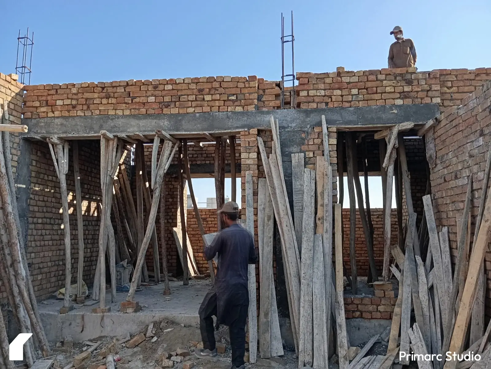 Laborers working on the roof construction of a 5 marla house in Rawalpindi. The team is laying bricks and finalizing the shuttering for the ground floor roof, showcasing a key stage in modern residential construction.