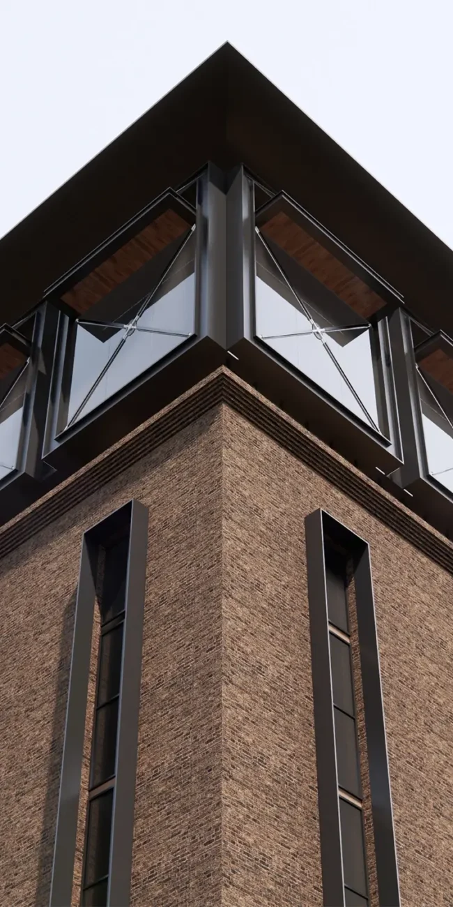 A low-angle, upward view of the corner of Jehangir Plaza, showcasing the texture of the brown brickwork contrasted with the modern black window frames and reflective glass. The image emphasizes the verticality of the narrow windows on the lower levels and the unique angled windows on the upper floor beneath the dark roofline.