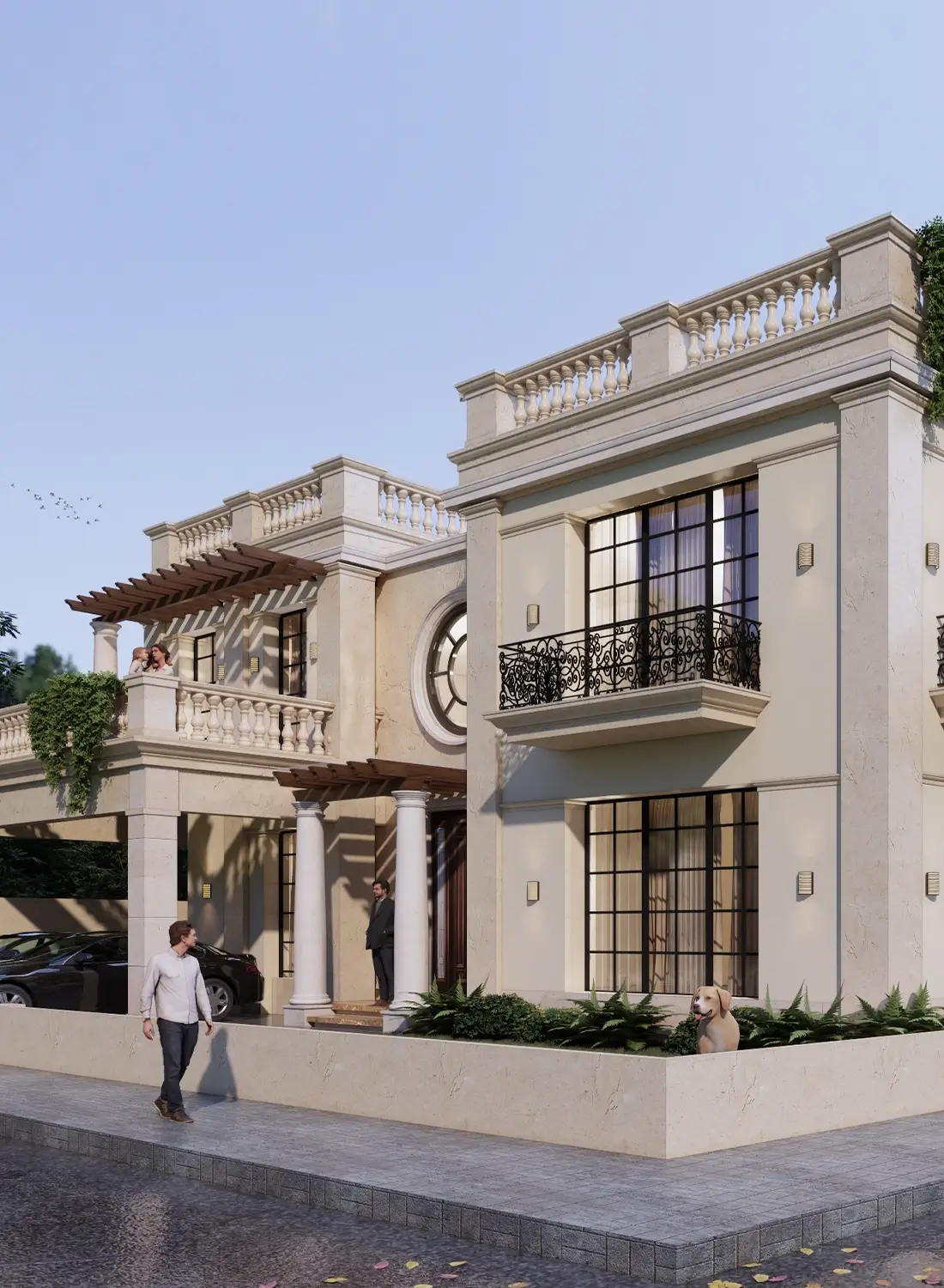 Exterior view of a two-story classic-style house with a light-colored facade, wrought-iron balconies, and a decorative balustrade on the upper level. The house features large windows, a prominent circular window detail, and a covered entrance with white columns and a wooden pergola. A man is walking on the pavement in front, another man stands near the entrance, and a dog sits on the low boundary wall. Two cars are parked under a covered area to the left. Lush greenery surrounds the property under a clear sky. Located in Zaraj Housing Society, Islamabad, for Mr. Murad Shabbir.