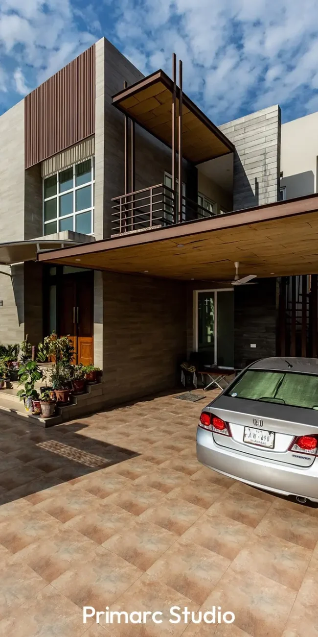 Comprehensive front view of the modern architecture of the 1 Kanal contemporary residence in Bahria Enclave Islamabad, showcasing the clean lines, minimalist exterior design, integrated parking shed, entrance, and the strategic use of facade materials, reflecting thoughtful architectural planning.