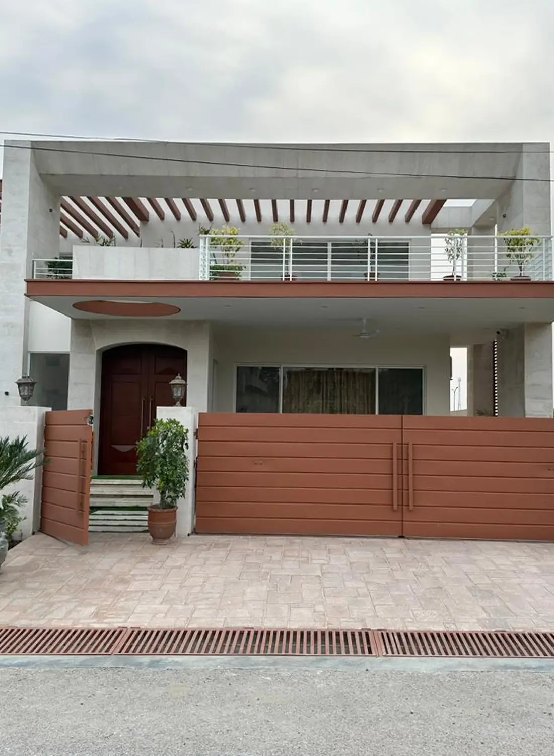 Exterior view of a modern 1 Kanal home in Naval Anchorage, Islamabad, featuring contemporary design by Primarc Studio. Shows the entrance gate and facade.