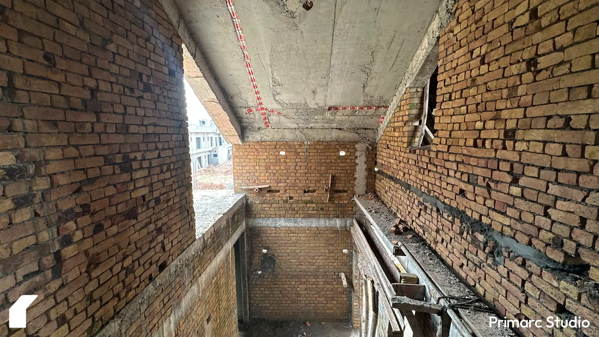 View from upper floor showing exposed brickwork, structural beams, and unfinished ceiling in a one kanal contemporary Islamabad house.