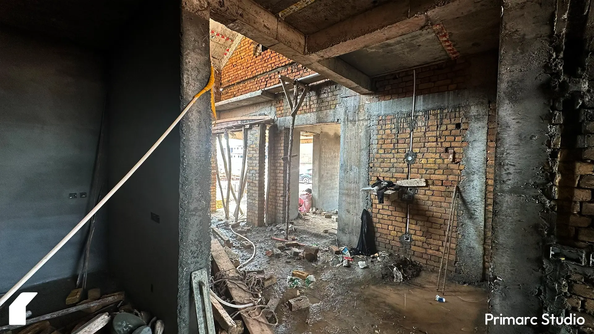 Ground-level interior under construction in Park View City with brick walls, concrete pillars, and visible electrical conduits.