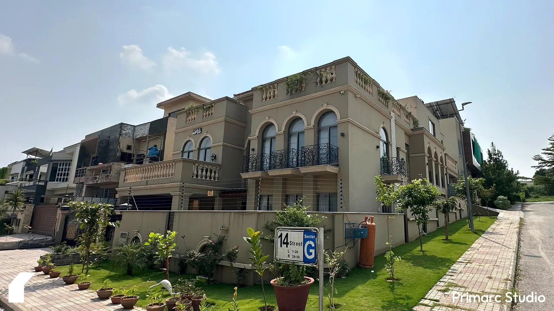 Corner street view of Noman House in DHA Phase 2 Islamabad, a 1 kanal classical house with landscaped frontage, arched windows, and balconies.