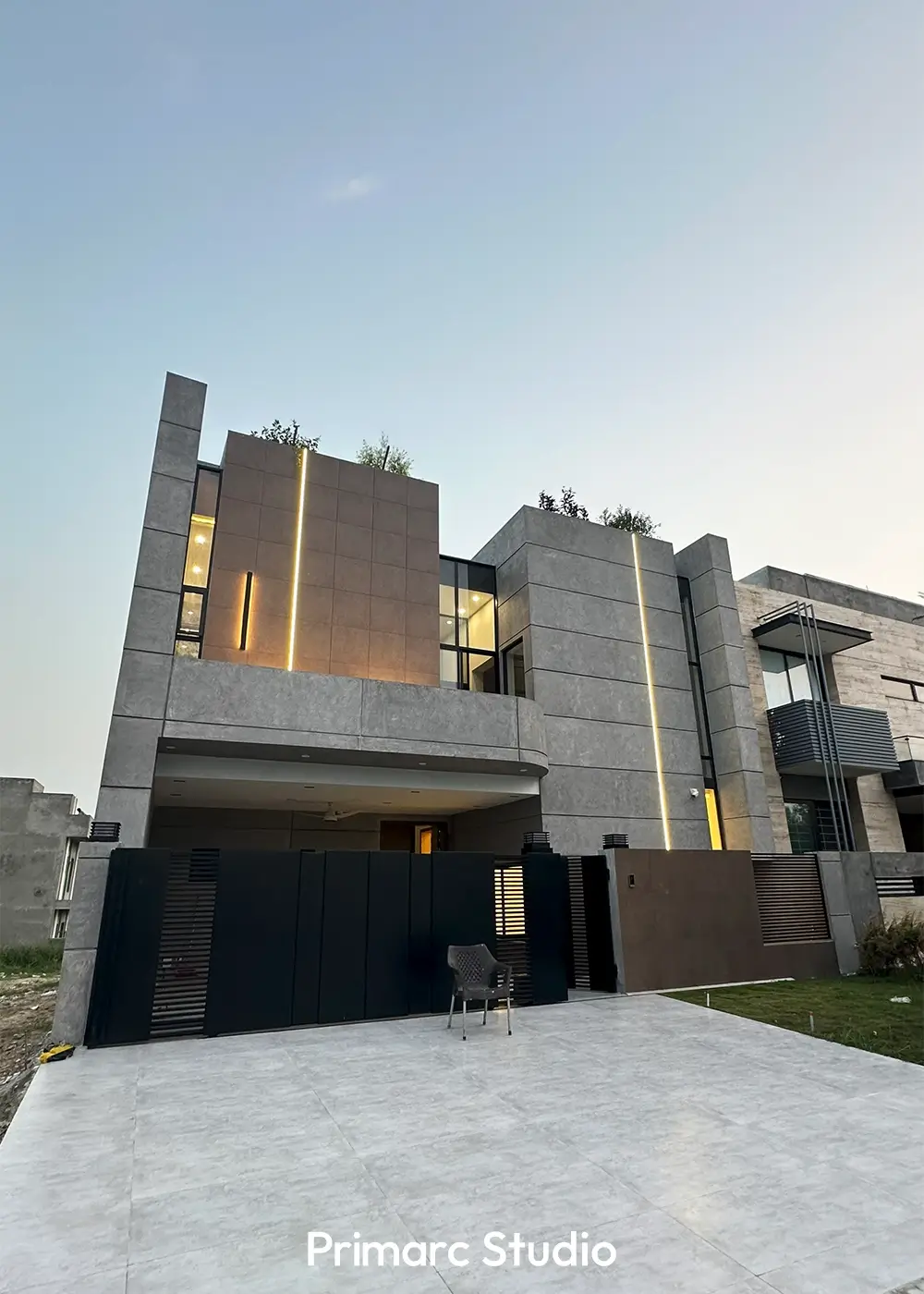 Front exterior view of a 10 marla modern home in Gulberg Residencia Islamabad with concrete and glass façade by Primarc Studio.