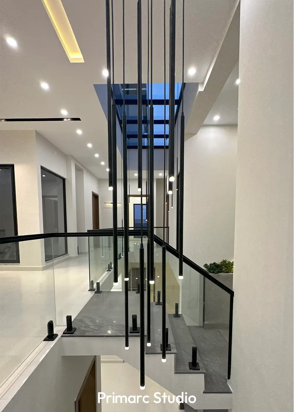 Glass railing corridor overlooking atrium with pendant lights in 10 marla house Gulberg Residencia Islamabad.
