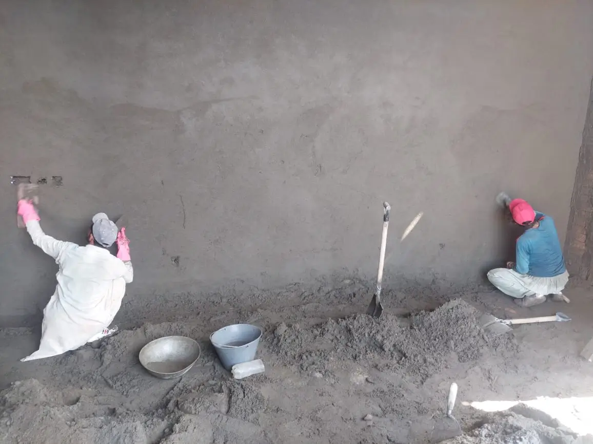 Construction workers plastering interior wall of 1 Kanal house design in Park View City Islamabad.