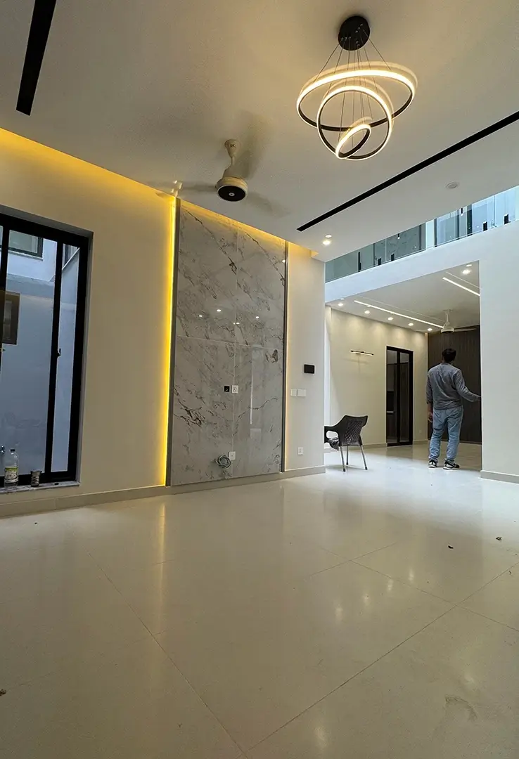 Spacious dining and living area of Haider House in Gulberg Residencia Islamabad with marble wall, LED lighting, and modern ceiling design by Primarc Studio.