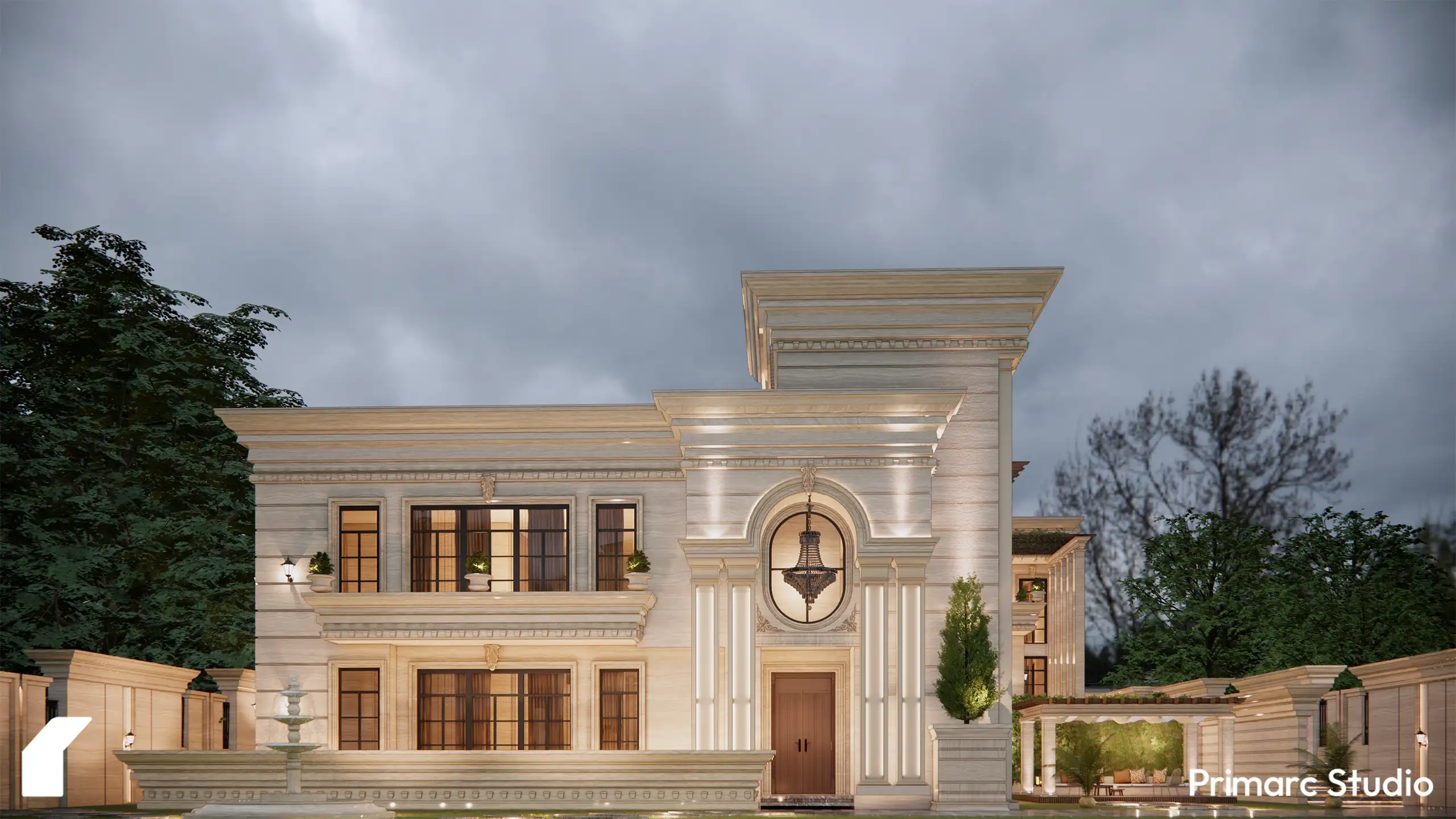 Evening view of a classical farmhouse wing showing a decorative circular window, carved stone cornices, and a cozy lit outdoor sitting area.